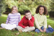 3 children sitting on grass